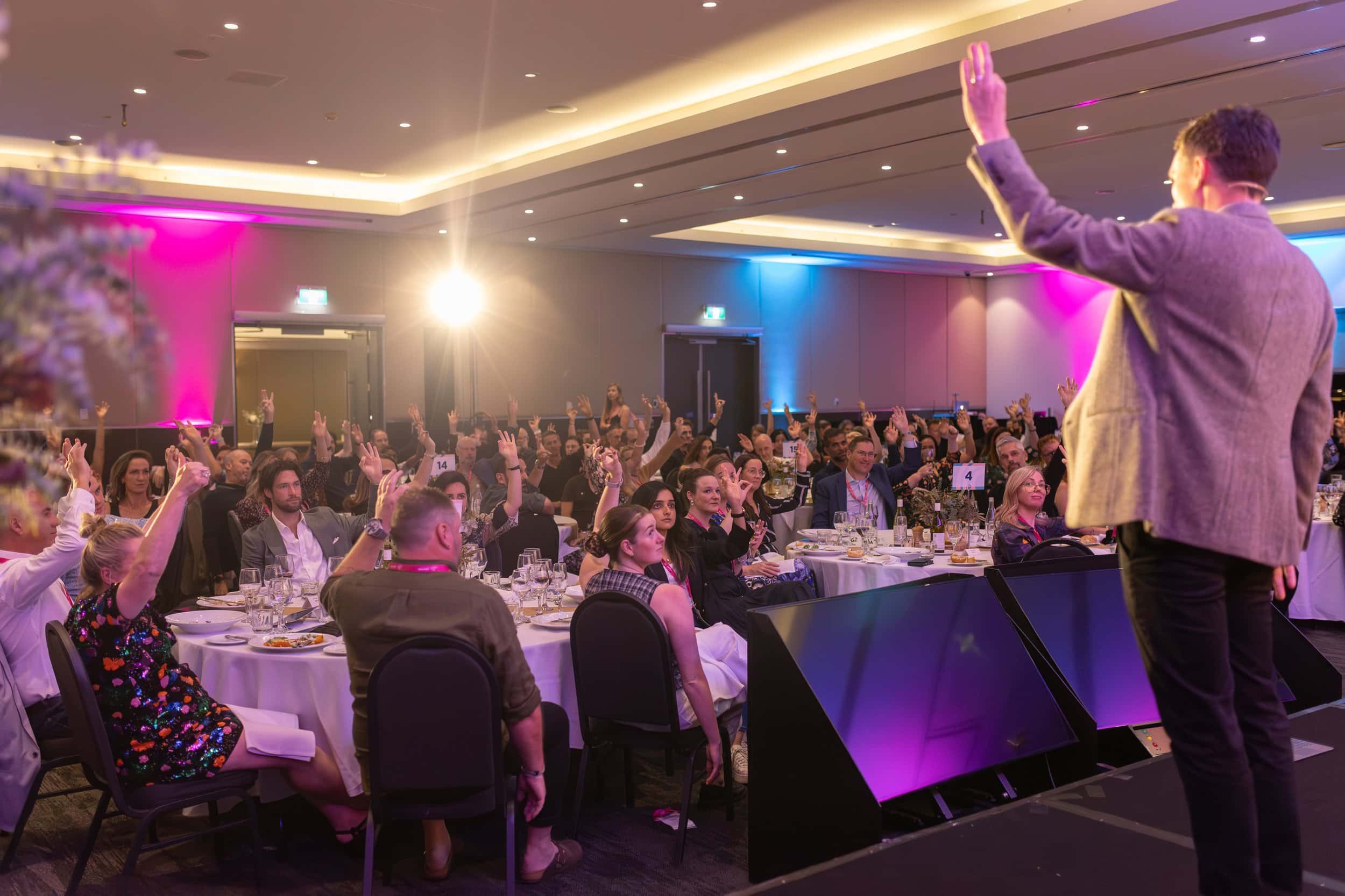 Andy Nunn speaking to a large seated audience at a corporate event