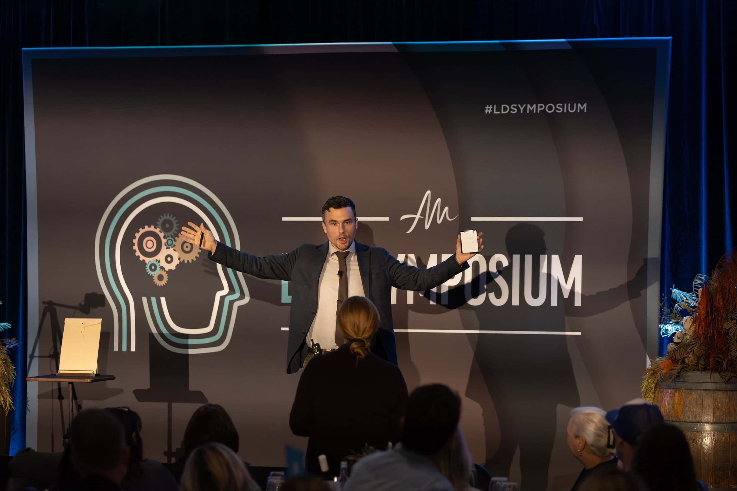 Andy Nunn presenting beside a projected illustration of the human mind