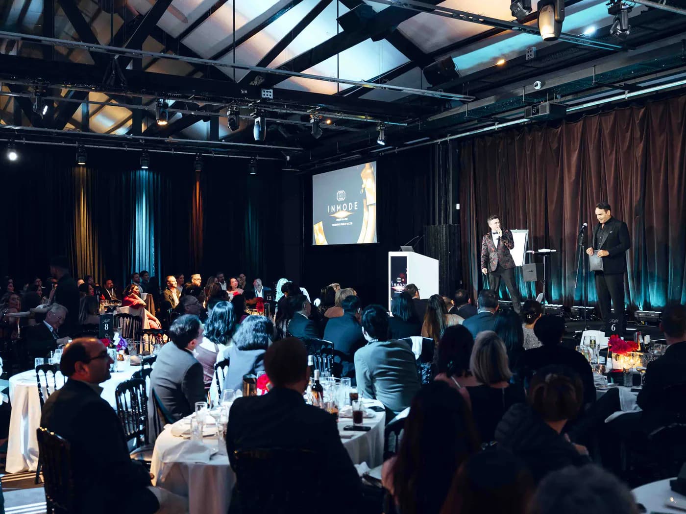 Andy Nunn presenting to guests in a black-tie corporate venue
