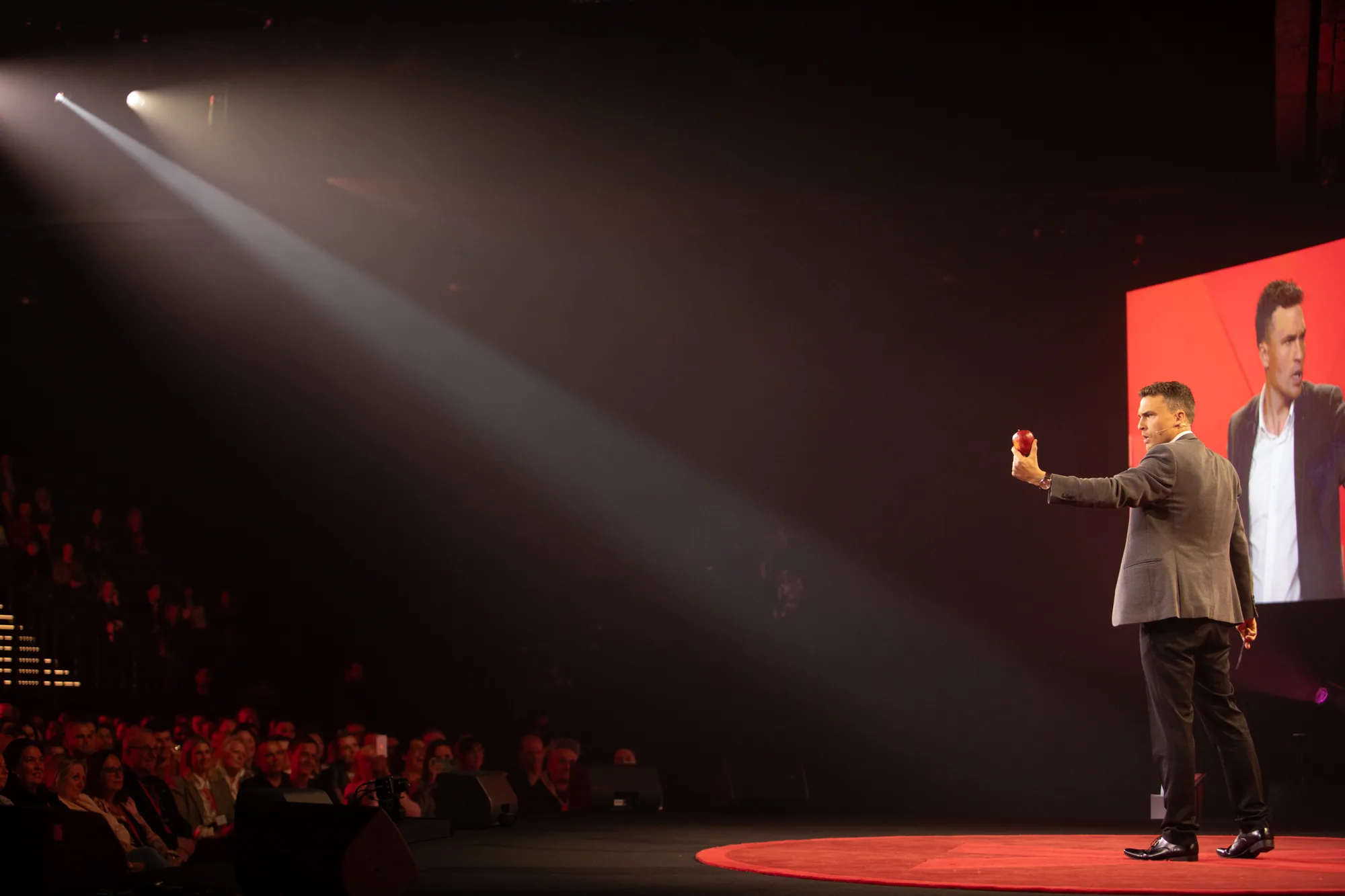 Andy Nunn presenting on a large theatre stage as a motivational speaker