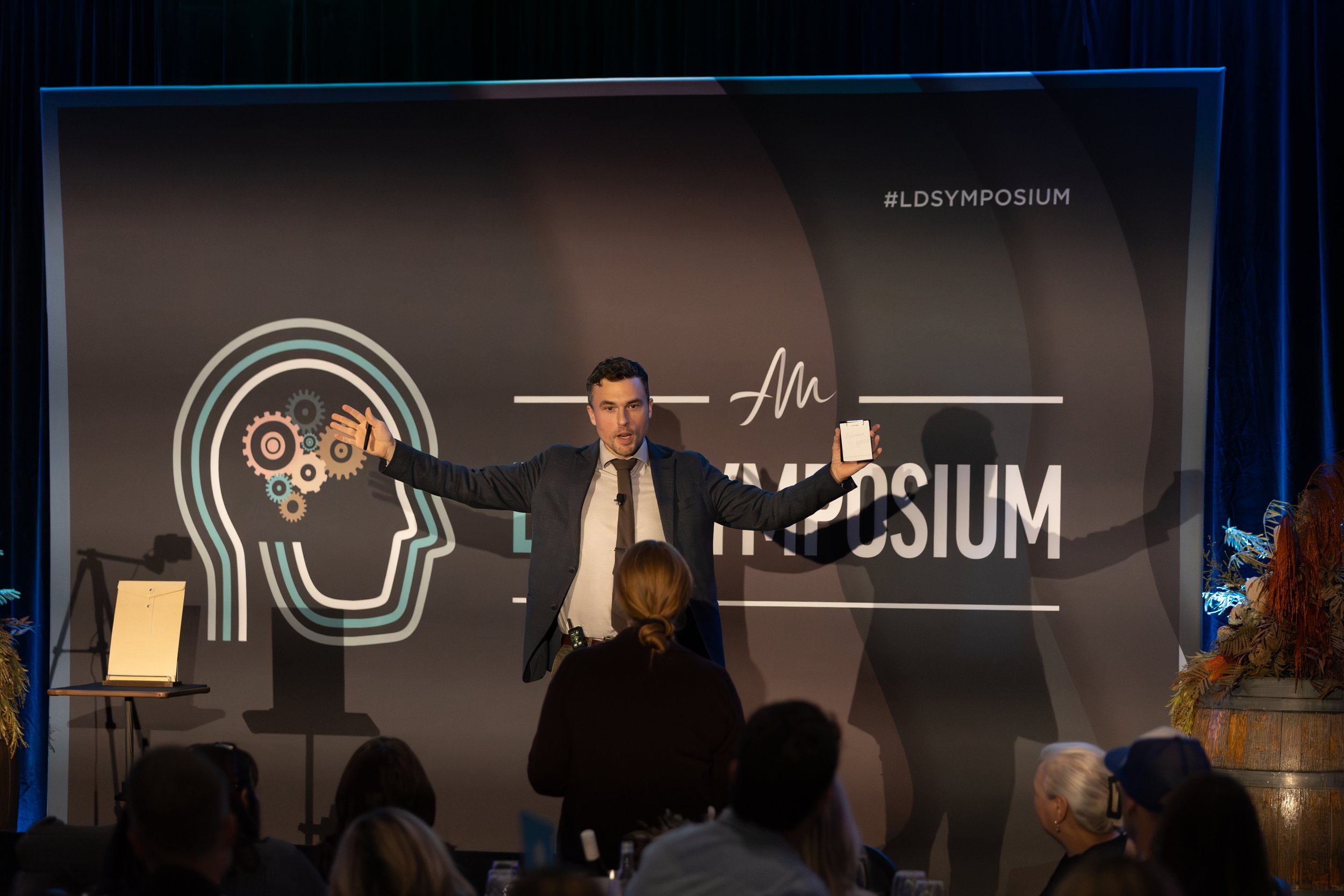 Andy Nunn presenting beside a projected illustration of the human mind