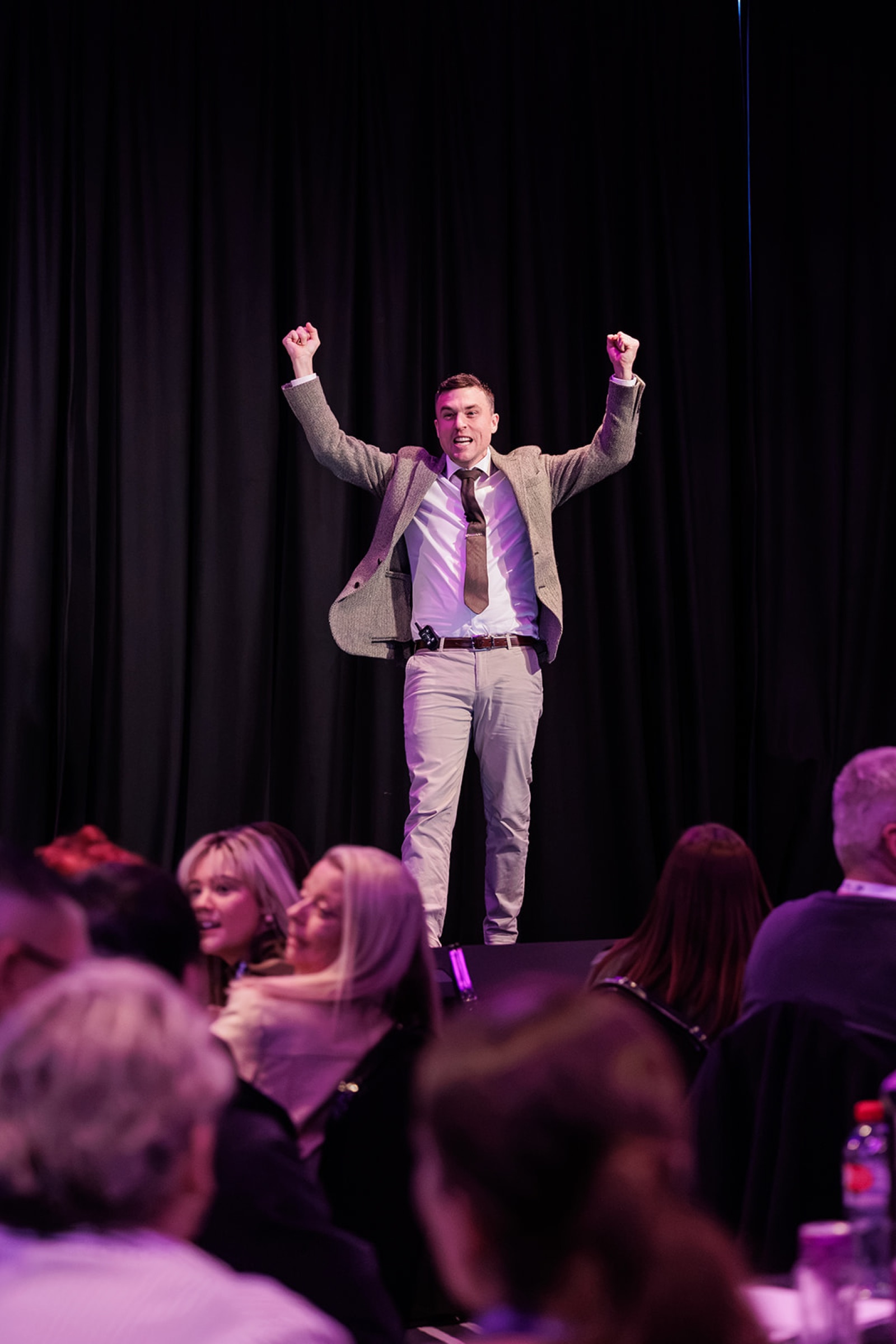 Andy Nunn celebrating on stage with a corporate audience at the BDM Summit