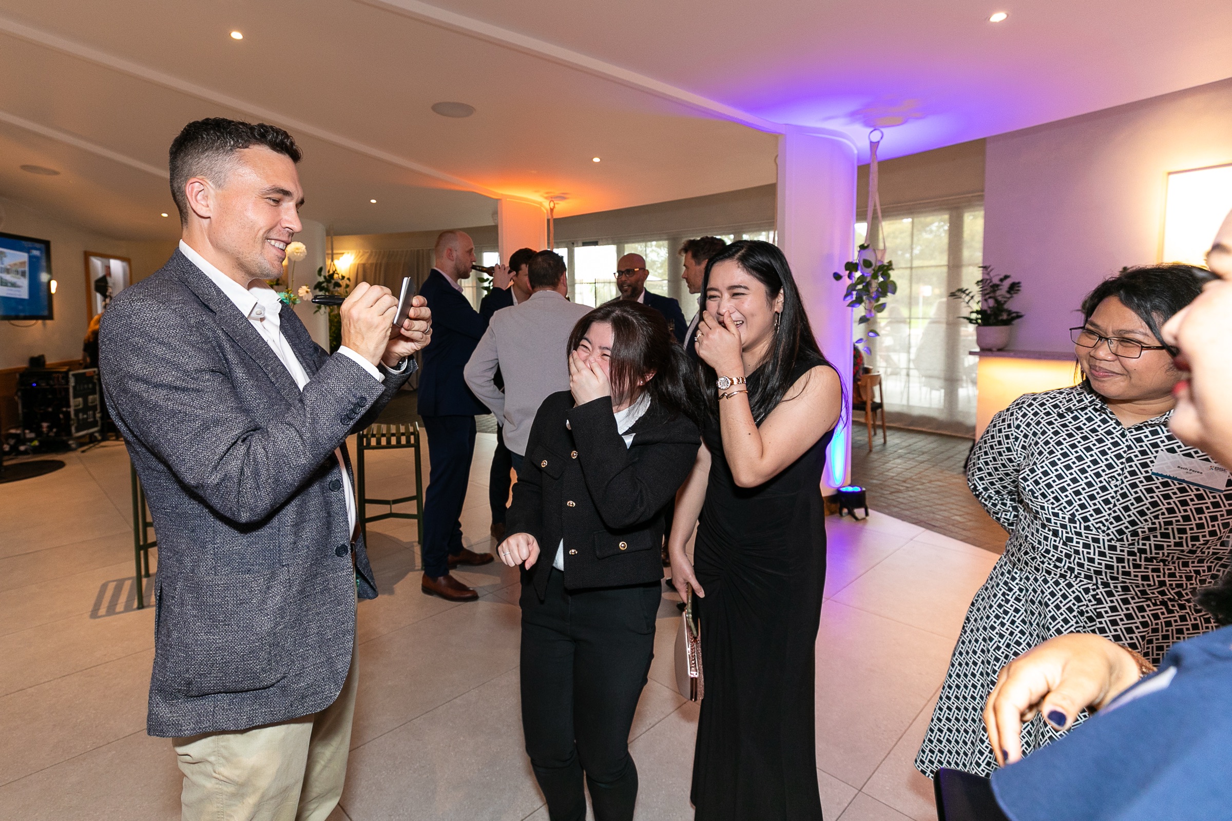 Guests laughing as Andy Nunn performs close-up mentalism at a corporate anniversary event