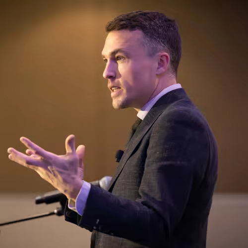 Andy Nunn speaking on stage during a mentalism performance