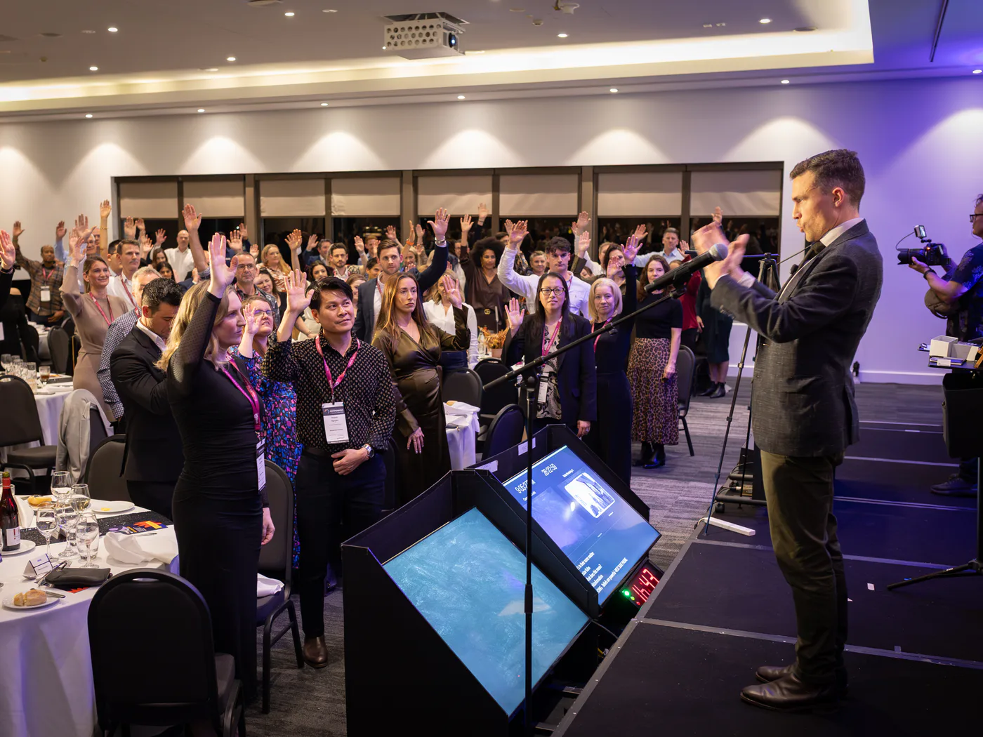 Andy Nunn inviting event guests to raise their hands during an interactive session