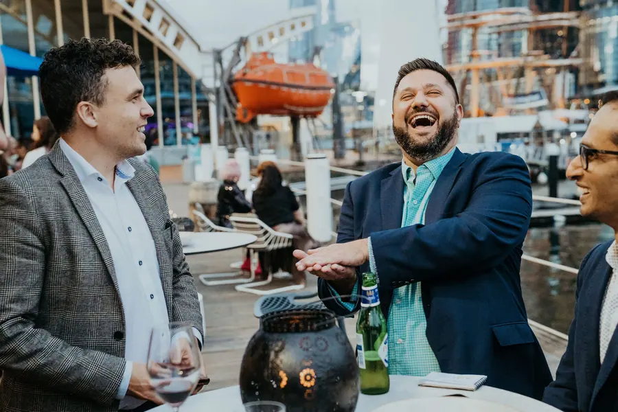 A corporate guest laughing during Andy Nunn's roving mentalism in Sydney