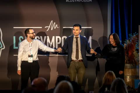Smiling participants joining Andy Nunn on stage at a Sydney corporate event