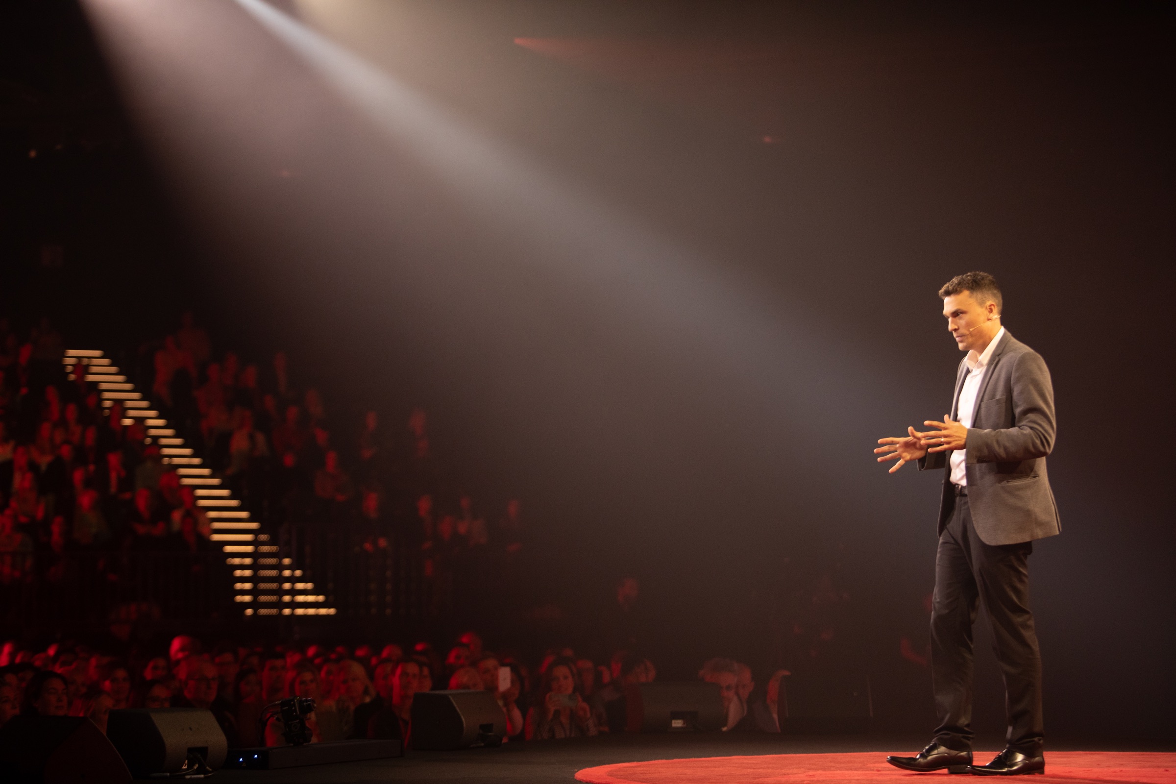 Andy Nunn presenting a keynote under stage lights in New Zealand