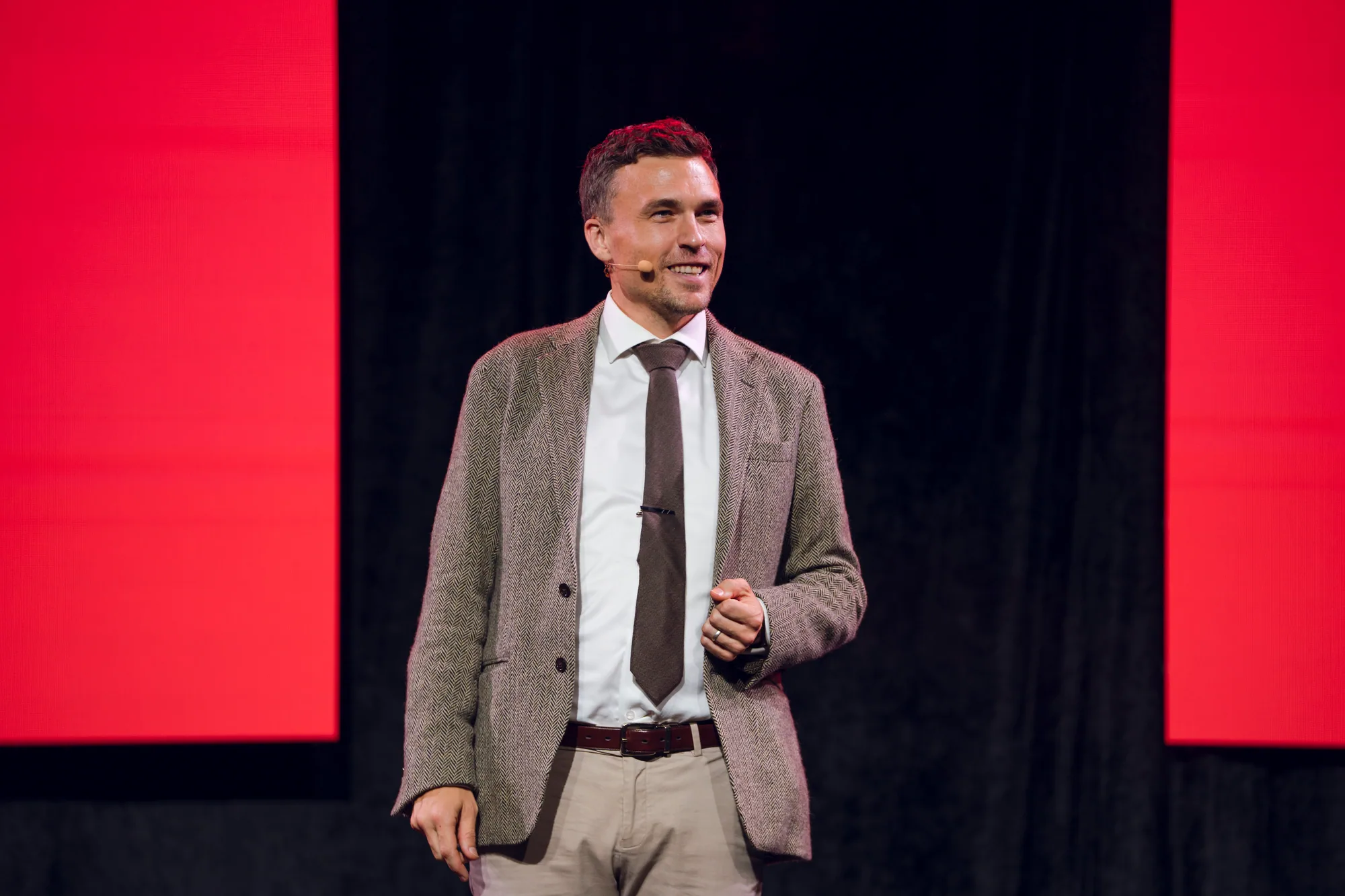 Andy Nunn speaking on stage in a grey jacket